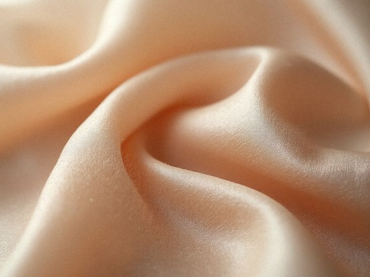 Detail hodvábnej látky, zdôrazňujúci jej kvalitu a textúru